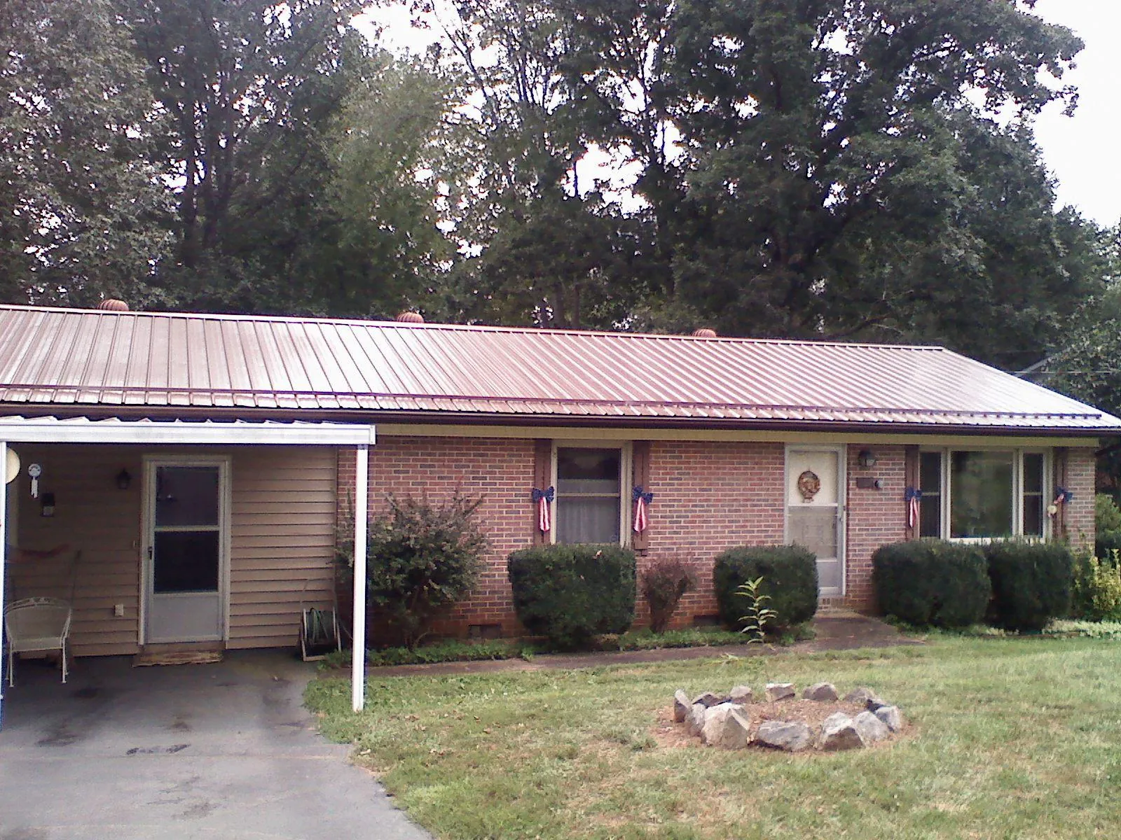 Bronze metal roof and carport on a brick ranch home — Roof Repair work by our crew in Waucoma